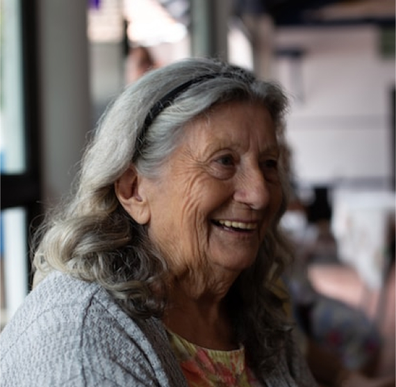 An elderly woman smiling in a restaurant